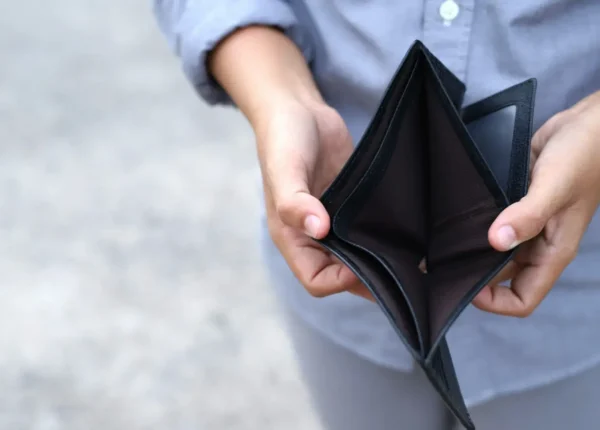 mężczyzna otwierający pusty portfel